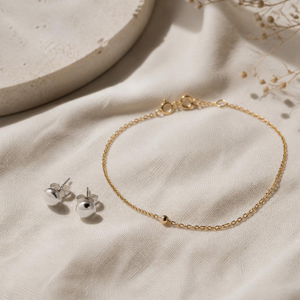 Silver stud earrings and thin yellow gold beaded chain bracelet