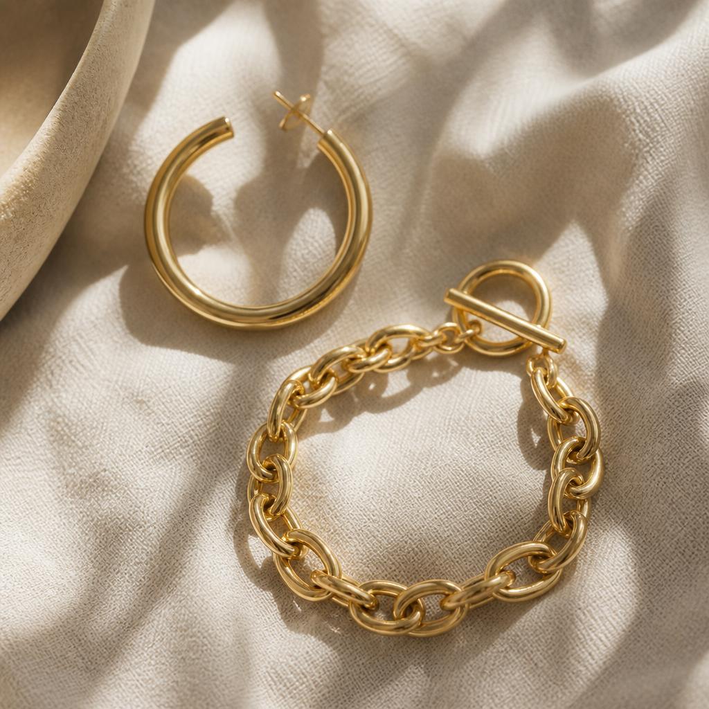 Large yellow gold hoop earring and chunky gold chain bracelet
